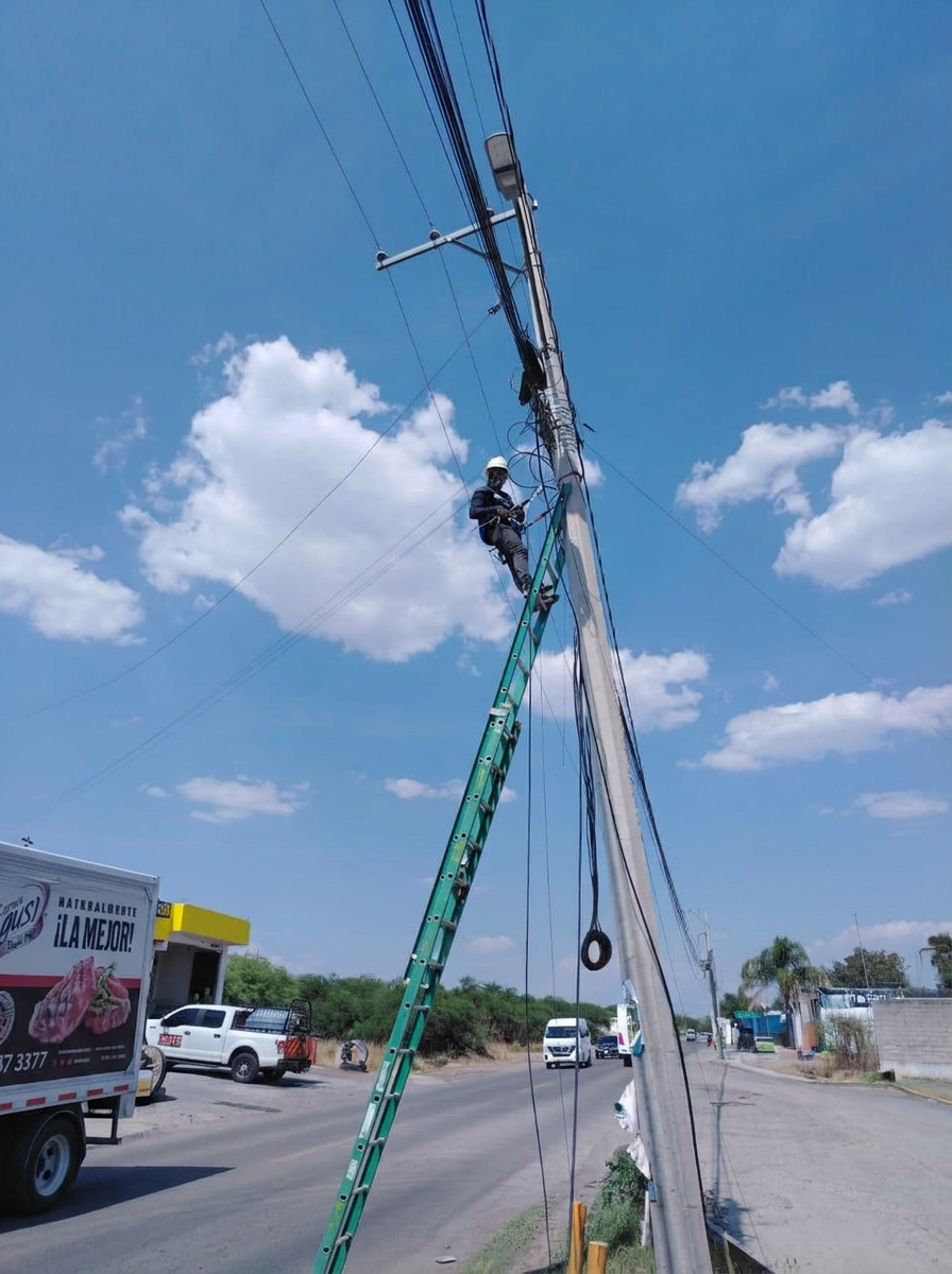 Técnico de GYBO en escalera trabajando en un poste de fibra óptica